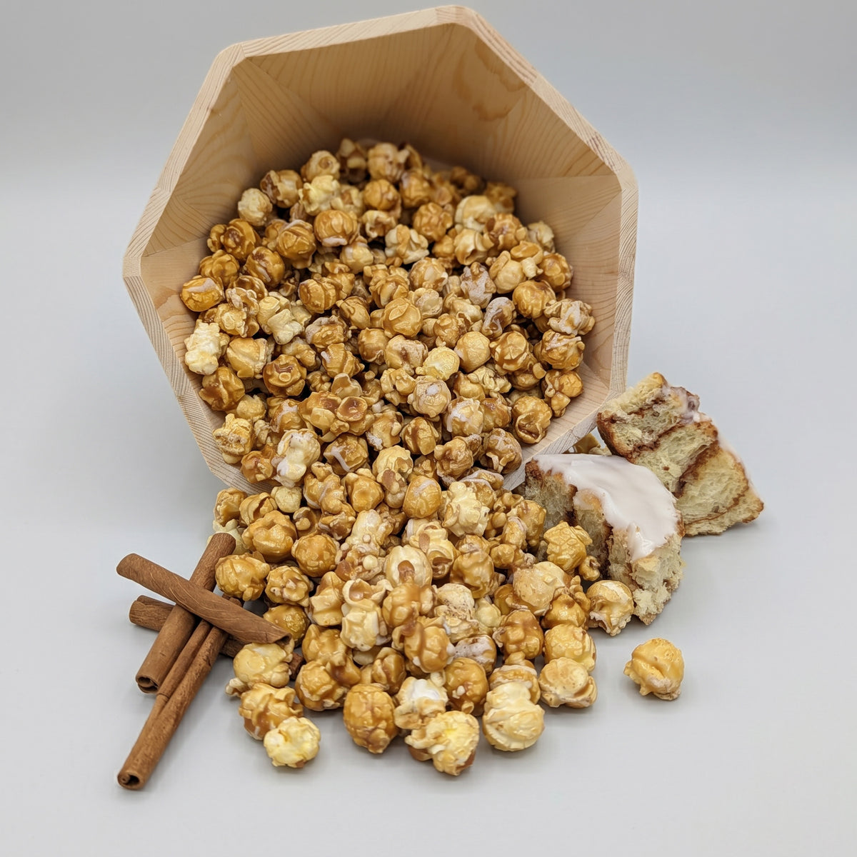 Iced Cinnamon Roll The Popcorn Loft flavored popcorn with white chocolate icing drizzle in golden caramel tones