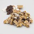 S'mores popcorn with graham crackers, chocolate, and marshmallows on a light background
